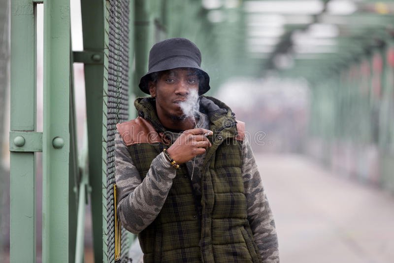 handsome-black-man-smoking-cigarette-young-iron-bridge-european-city-95859426.jpg